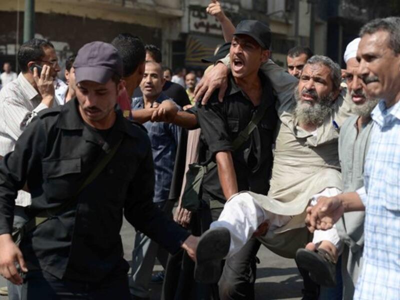Egyptian policemen carry an Islamist man outside Cairo's Al-Fath mosque where Islamist supporters of ousted president Mohamed Morsi held up on August 17, 2013. (AFP)