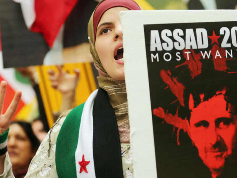 Protestors outside the UN General Assembly in New York hold anti-Assad signs