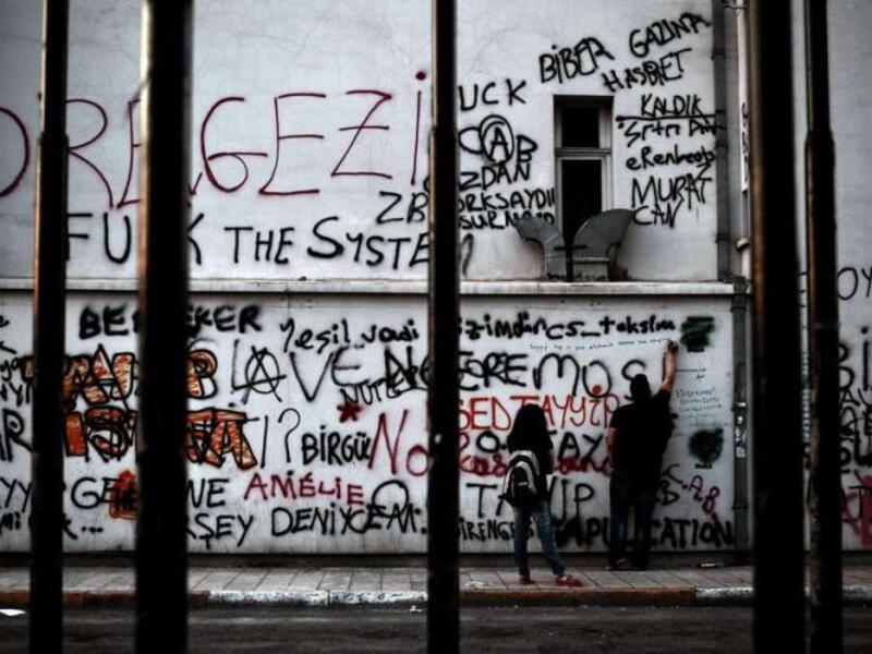 A demonstrator writes slogans on a building painted with graffiti at Taksim square in Istanbul on 6 June 2013. (Photo: AFP - Aris Messinis)