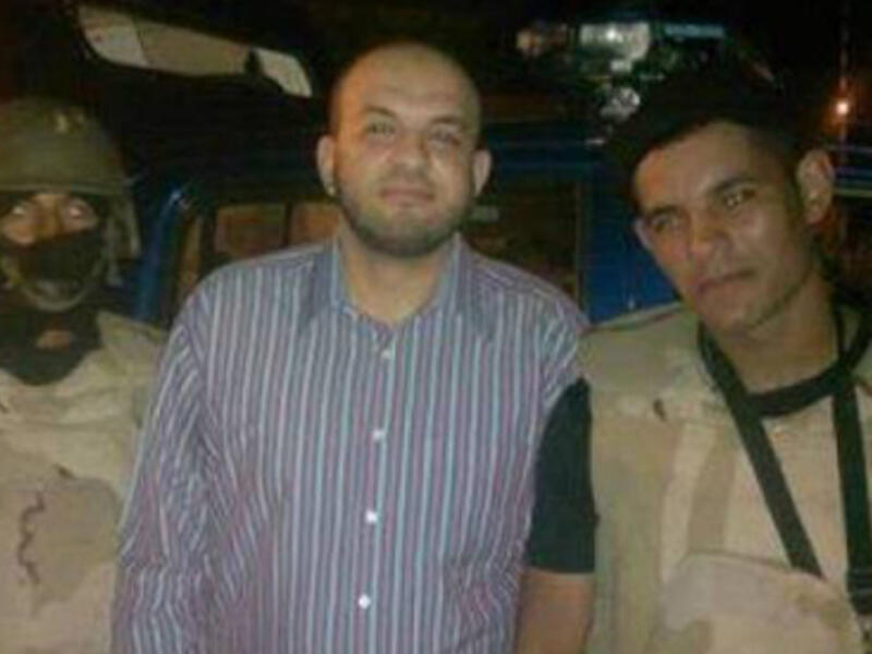 Ahmed Arif is seen smiling with the police that arrested him. (Egyptian police Facebook)