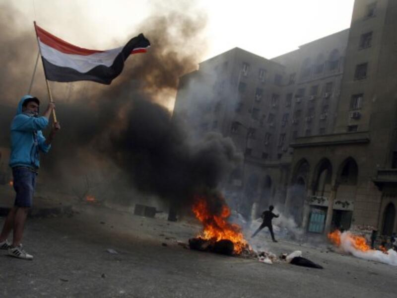 Tires burn as Egyptian Muslim brotherhood and supporters of ousted president Mohamed Morsi take part in clashes with riot police along Ramsis street in downtown Cairo, on October 6, 2013 (AFP)