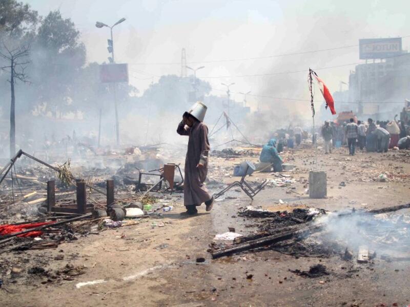  supporter of Egypt's ousted president Mohamed Morsi walks through the debris following clashes with police in Cairo on August 14, 2013. (AFP)