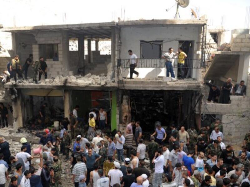 Civilians and security at the scene of a bombing in the Mezze 86 area of Damascus (AFP/SANA)