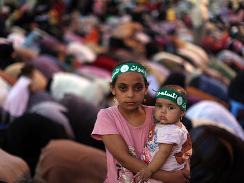 An Egyptian girl holds a baby as supporters of the Muslim Brotherhood pray on July 10, 2013. (source: AFP PHOTO / MAHMUD HAMS)