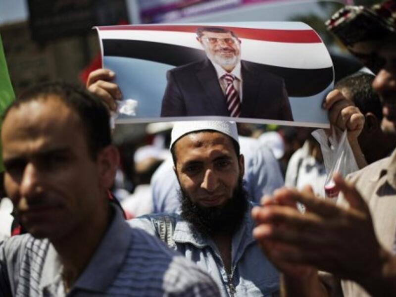 A protester is seen with a picture of President Mohamed Morsi, at the Rabaa al-Adawiya mosque in Cairo, on June 28, 2013 (AFP/File)