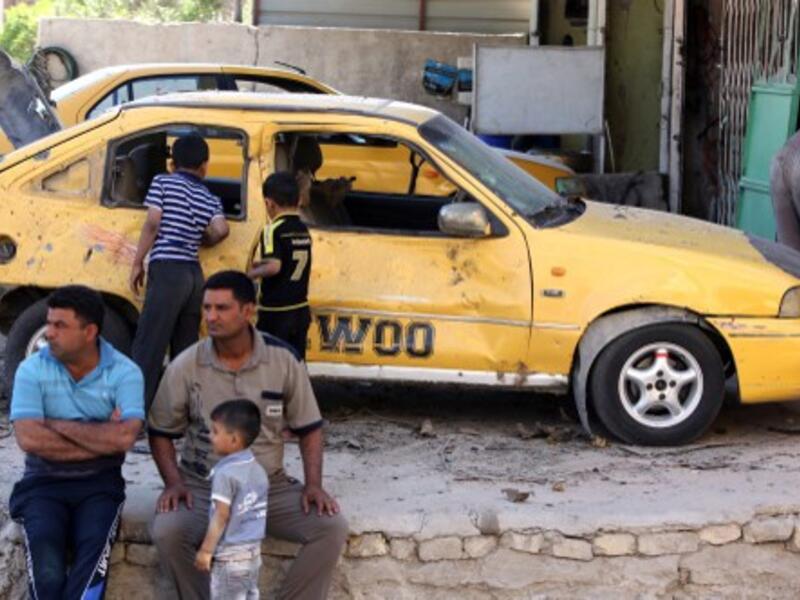Iraqis look on at the site of a car bomb attack the evening, before in the Zafaraniyah area south of Baghdad, on October 8, 2013. A wave of car and roadside bombs hit Iraq on Sunday morning, killing at least 8 people. (AFP)
