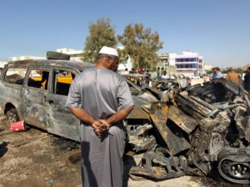 Benghazi residents gather at the site of a car blast in the parking lot of school used as an electoral office on October 26, 2013. On Sunday night, a Libyan intelligence officer and his two-year old son were killed in a car bomb attack. (AFP)
