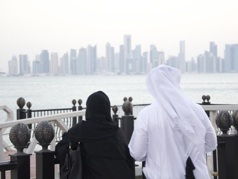 A man and woman look out at the Doha Skyline (Albawaba/J. Zach Hollo)