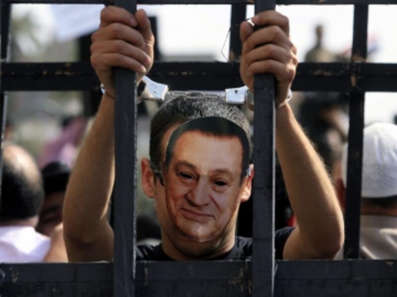 A critic of former Egyptian president Mubarak is seen wearing a mask of his face in Cairo. (AFP/File)