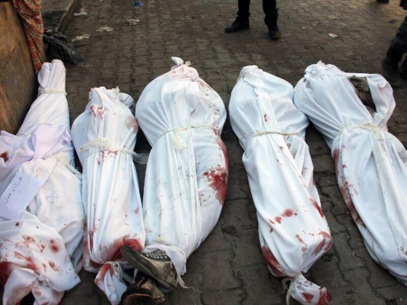 Bodies of victims from an airstrike on the Maadi neighbourhood of the northern Syrian city of Aleppo are seen on the ground wrapped in shrouds on December 17, 2013. This picture was taken on the third day of the bombing campaign - it is now entering its ninth. (AFP)
