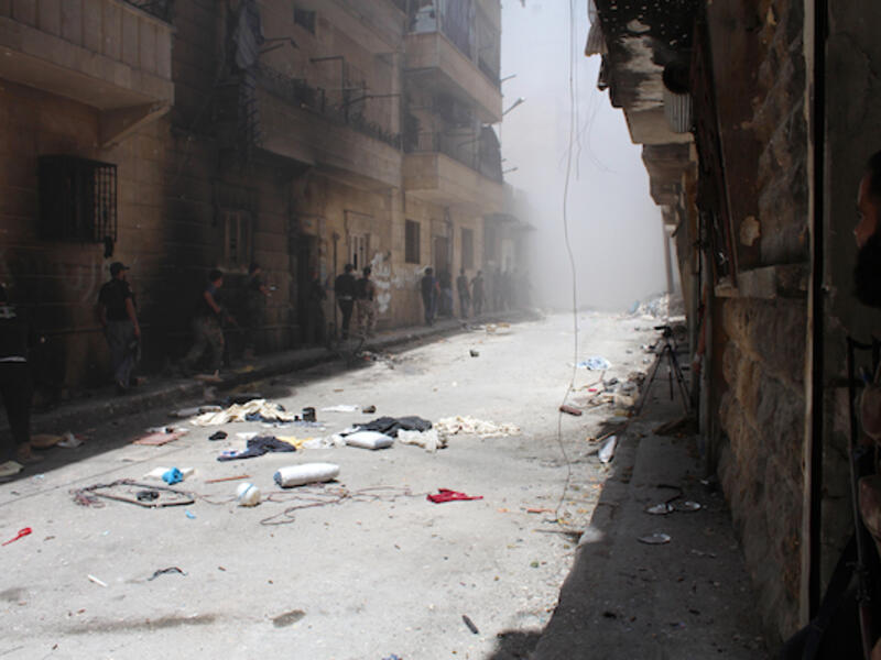 Syrian rebels gather outside a building which they blew up to target a regime sniper (Source: AFP/SALAH AL-ASHKAR)
