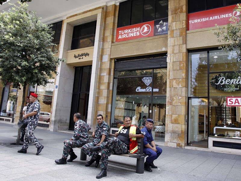 Members of the Internal security forces sit outside the Turkish Airlines offices in downtown Beirut (AFP/JOSEPH EID)