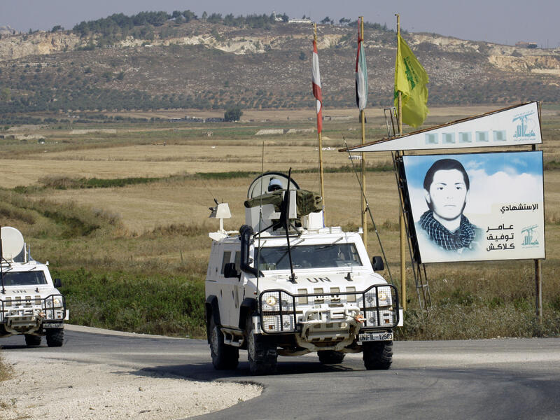 Spanish peacekeepers of the United Nations Interim Force in Lebanon (UNIFIL) patrol in their armoured vehicles near a placard of Hezbollah (AFP/MAHMOUD ZAYYAT)