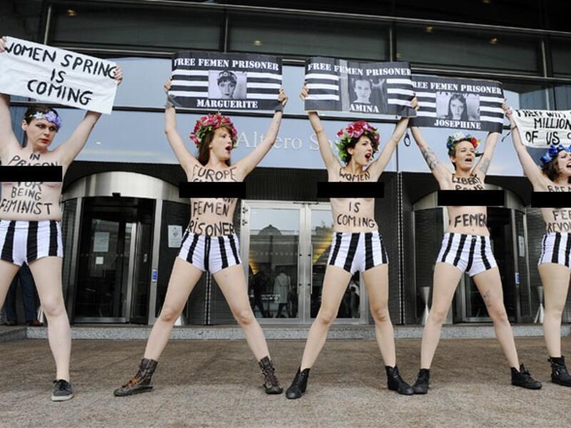 Members of the women's topless protest group Femen hold banners during a protest in front of the European Union Parliament in Brussels, to support a detained Tunisian activist and three European activists detained in Tunis. AFP photo