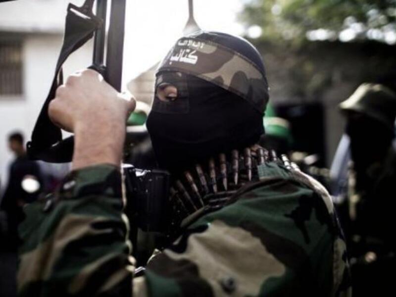 A Hamas member holds a gun during a march.