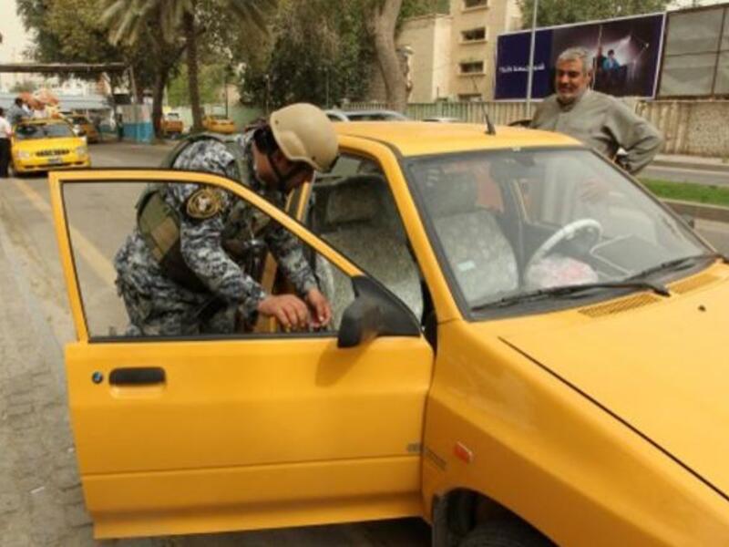  A federal policeman inspects a vehicle in front of government buildings on Sunday in the Iraqi capital Baghdad. (Photo: AFP / Sabah Arar)