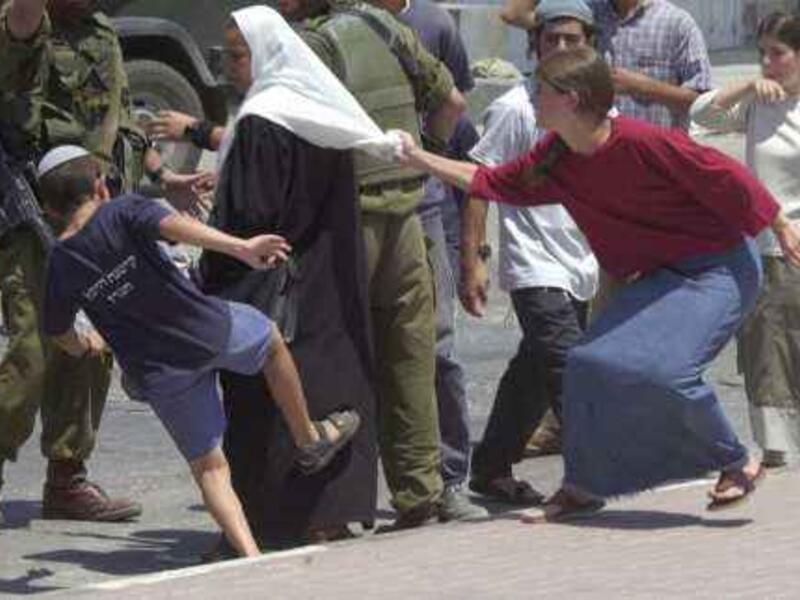Israeli settlers harass a Palestinian woman in the West Bank (File)