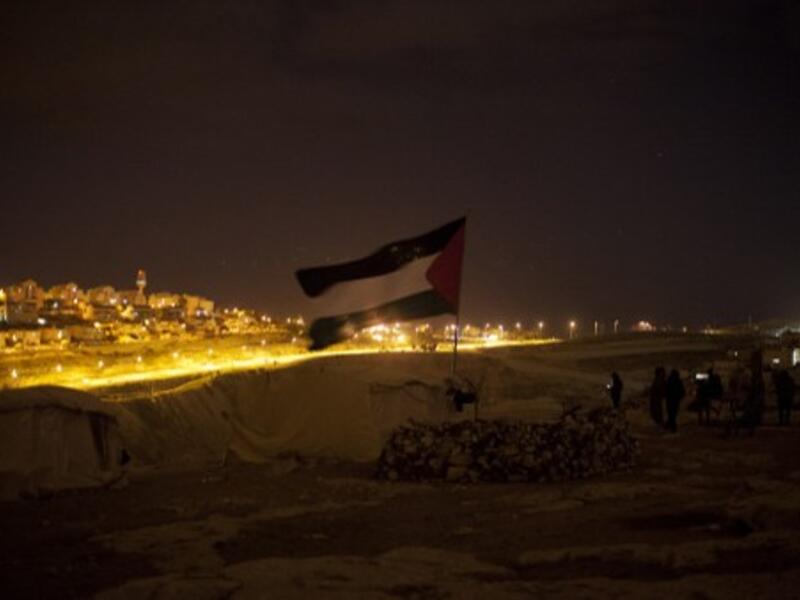 A Palestinian flag flutters at a protest camp in the controversial West Bank area known as E1 located east of Jerusalem and near the Jewish settlement of Maaleh Adumim early on Sunday. Hundreds of Israeli police dismantled the protest camp on the outskirts of Jerusalem overnight, activists and police said. (Photo: AFP / Ahmad Gharabli). 