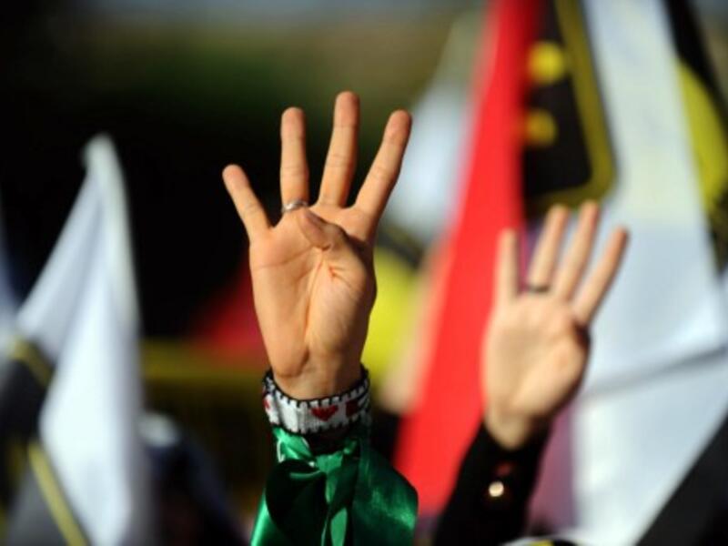 A Turkish muslim woman makes the "Rabia sign" during a rally on August 25, 2013. (AFP)