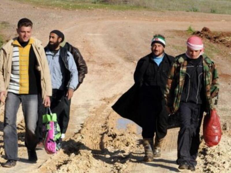 Syrian refugees walk down a dirt track in Antakya, Turkey, shortly after crossing into the country from Syria.