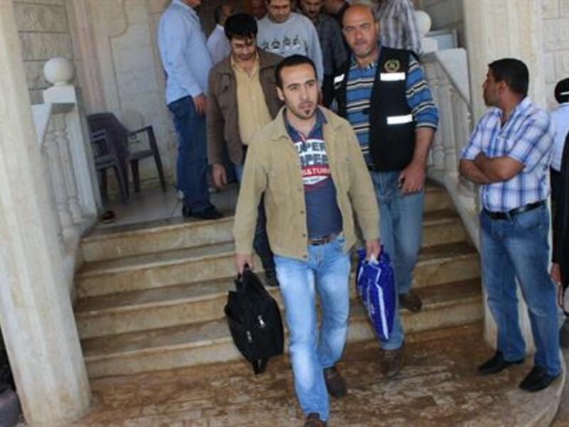 Army Intelligence personnel escort freed Syrians out of al-Ahmad family's residence in the village of Hisheh, north Lebanon, on Saturday, April 27, 2013. (The Daily Star/Antoine Amrieh)