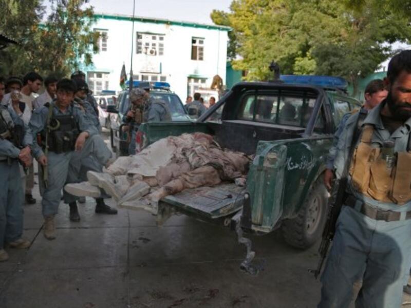 Afghanistan policemen stand near bodies of Taliban fighters, as they lie on a police vehicle in the grounds of the main hospital in Ghazni on September 1, 2013. (AFP)