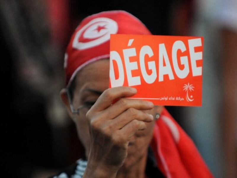 A Tunisian demonstrator holds a poster during a demonstration against the country's Islamist-led government in Tunis on August 24, 2013. (AFP)
