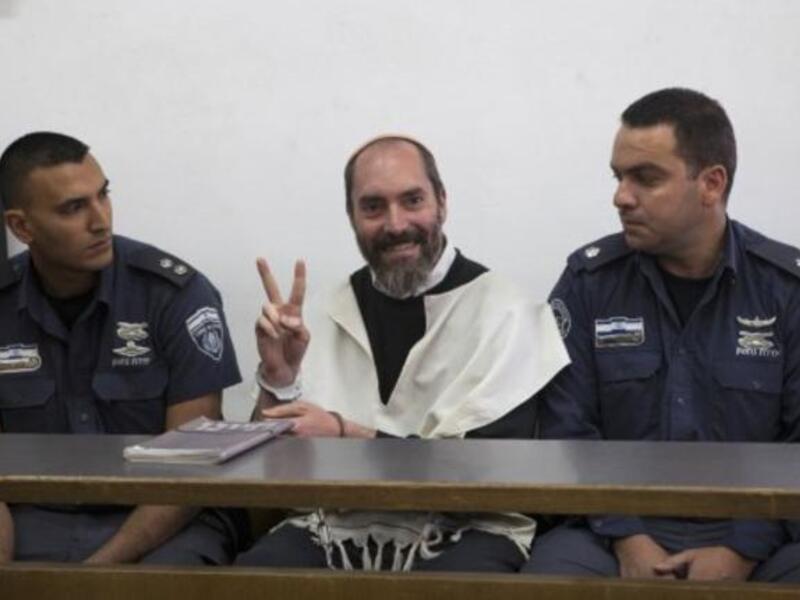 Israeli settler Yaakov Teitel flashes the "V" for victory sign prior to the start of his trial at the Jerusalem District Court on Tuesday. (Photo: AFP - Ahmad Gharabli)