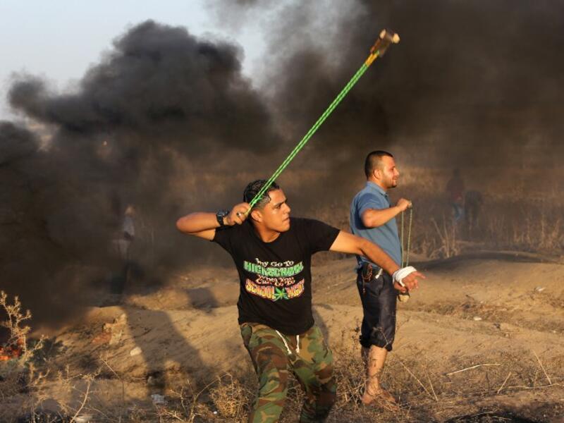 A Palestinian protester hurls a stone toward Israeli troops during clashes near a border fence between Israel and the Gaza Strip on Oct. 14, 2015 east of Bureij in central Gaza. (AFP/Mahmud Hams)