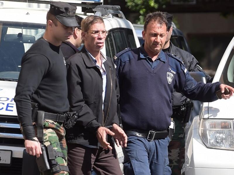 Seif al-Din Mohamed Mostafa, an Egyptian man who hijacked an EgyptAir passenger plane and forced it to divert to Cyprus demanding to see his ex-wife, wears handcuffs as he leaves court in Larnaca escorted by Cypriot police on March 30, 2016. (AFP/George Michael)