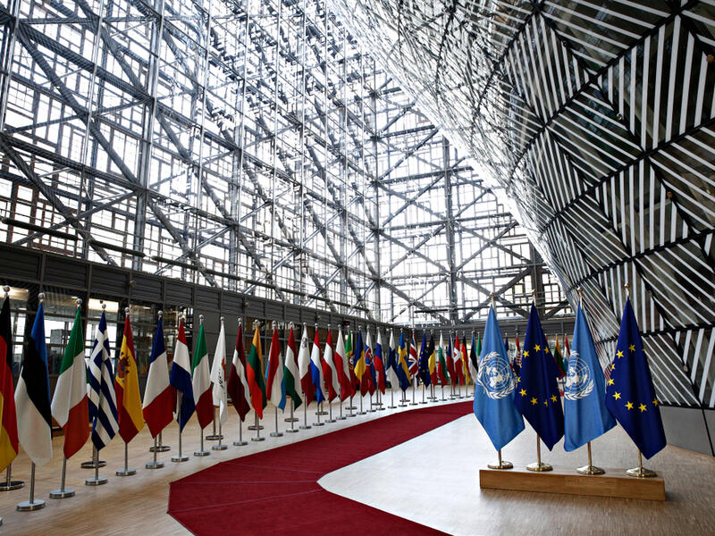 Flags of UN and EU stand in European council Building (Shutterstock)