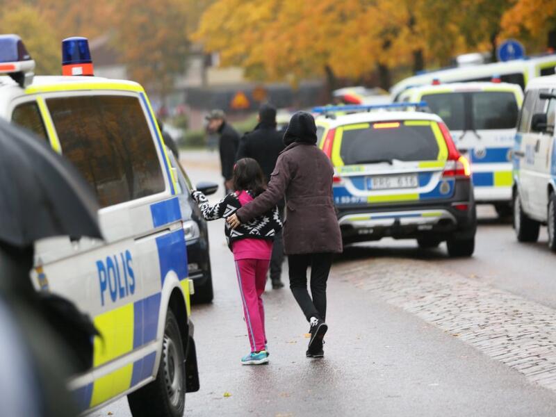 A pupil and her parent leaves a primary and middle school in Sweden where a masked man armed with a sword assaulted teachers and students. (AFP/File)