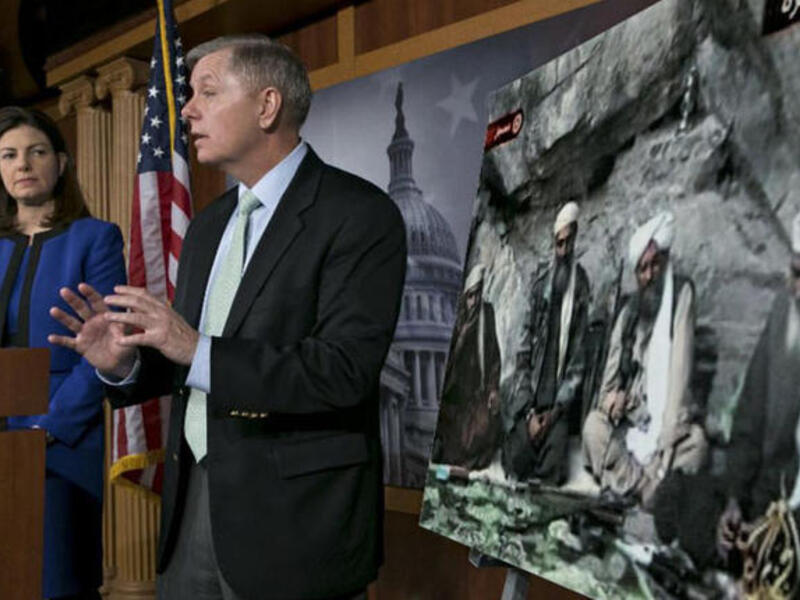 US Senator Kelly Ayotte talks about a photo of Sulaiman Abu Ghaith (L) during a press conference on Capitol Hill in Washington, DC. (AFP PHOTO/Brendan SMIALOWSKI)