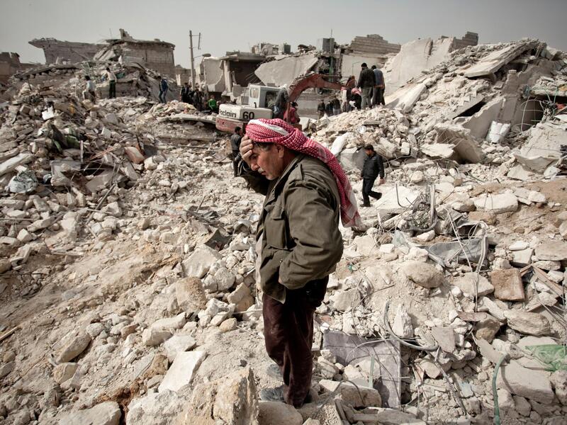 A Syrian man stands over the rubble of his house in Aleppo on February 23, 2013.  (AFP/Pablo Tosco)