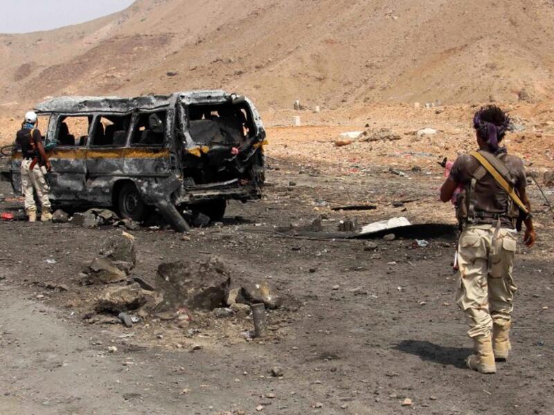 Yemeni soldiers examine the aftermath of a car bomb in Mukalla on July 18, 2016. (AFP/Abduljabbar Bajubair)