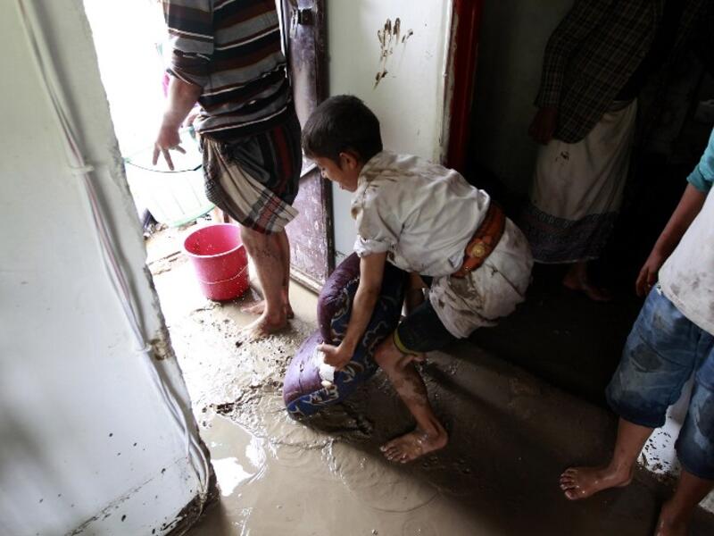 A boy helps clear the floodwaters from his home in Sanaa, Yemen. (AFP/Mohammed Huwais)