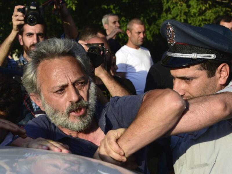 Armenian police detain an opposition supporter, artist Nikol Aghababyan, next to a police check point blocking the streets to Erebuni police station in Yerevan on July 17, 2016. (AFP/Karen Minasyan)
