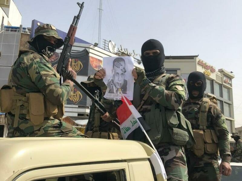 عناصر من مليشيا "ربع الله" يحملون صورة رئيس الحكومة العراقية مصطفى الكاظمي وعليها طبع حذاء