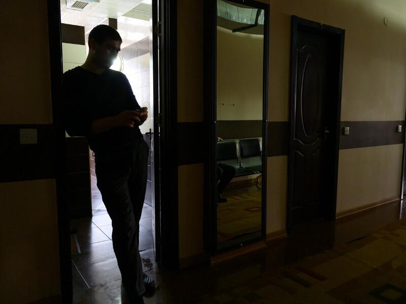 A man stands in a corridor at the Sehirli Naftalan Health Center, some 300 kilometres (186 miles) from capital Baku, on March 21, 2019. Immersed up to her neck in crude oil, a Russian woman suffering from joint disease smiles in delight, confident that the treatment at a spa in northwestern Azerbaijan will cure her painful condition.  Mladen ANTONOV / AFP