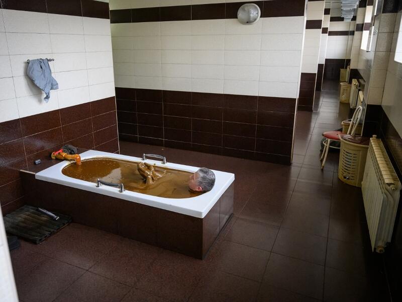 A man bathes in a tub filled with Naftalan crude oil during a treatment session at Sehirli Naftalan Health Center, some 300 kilometres (186 miles) from capital Baku, on March 21, 2019. Immersed up to her neck in crude oil, a Russian woman suffering from joint disease smiles in delight, confident that the treatment at a spa in northwestern Azerbaijan will cure her painful condition.  Mladen ANTONOV / AFP
