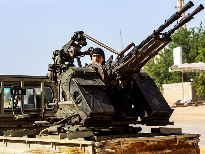 A Libyan fighter loyal to the Government of National Accord (GNA) mans a turret mounted on the back of a pickup truck during clashes with forces loyal to strongman Khalifa Haftar south of the capital Tripoli's suburb of Ain Zara, on April 10, 2019. Mahmud TURKIA / AFP