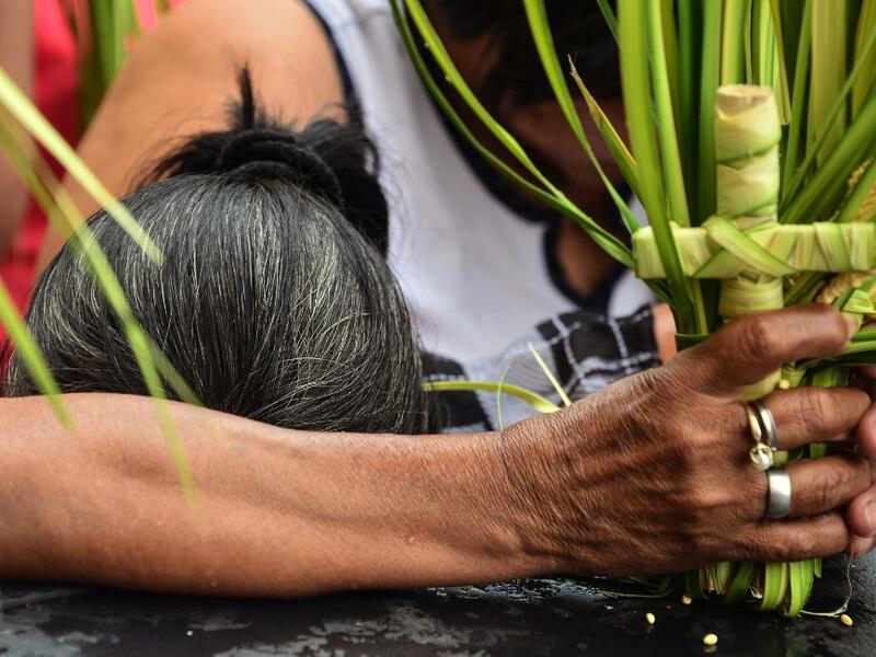 A Catholic faithful takes part in the traditional Palm Sunday procession in Tegucigalpa on April 14, 2019. For Christians, Palm Sunday marks the beginning of Holy Week, and commemorates Christ's triumphant entry into Jerusalem, before his arrest, trial, crucifixion and resurrection. It is traditionally marked by a procession and special mass.  ORLANDO SIERRA / AFP