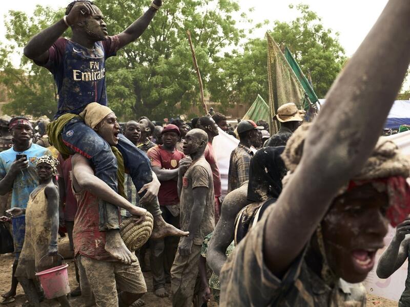 People take part in the annual rendering of the Great Mosque of Djenne in central Mali on April 28, 2019. Several thousand residents of the historic central Malian city of Djenne, a UNESCO World Heritage site, took part in the annual rendering ceremony of the Grand Mosque, which will now be powered by solar electricity. The rendering of the building with banco (a mixture of soil and water, with rice bran, shea butter and baobab powder) made by the city's inhabitants, helps to protect the mosque from bad wea