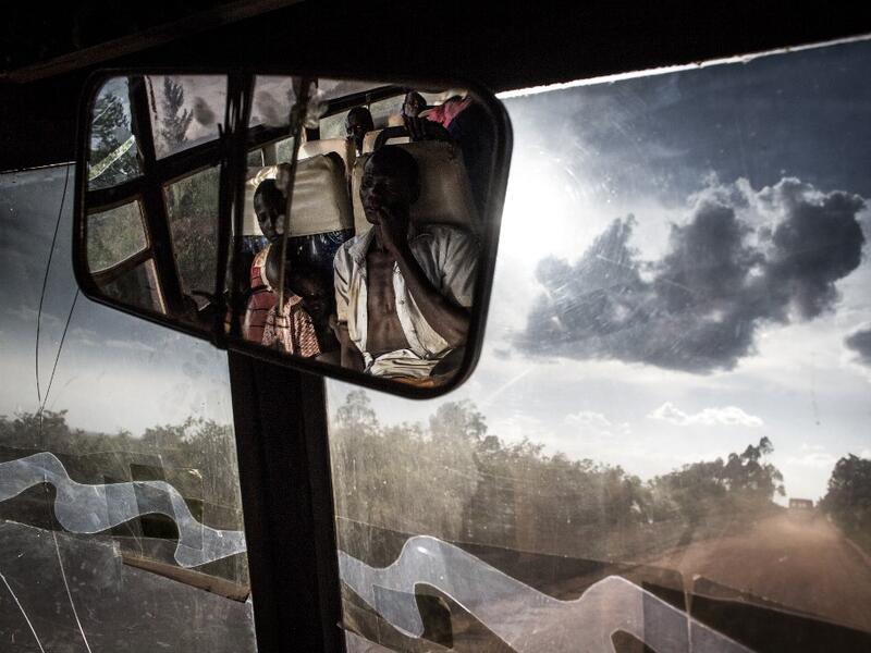 South Sudanese refugees transported by bus from the border of South Sudan to a refugees settlement site in Democratic republic of the Congo (DRC) are seen in the rear-view mirror of the bus JOHN WESSELS / AFP