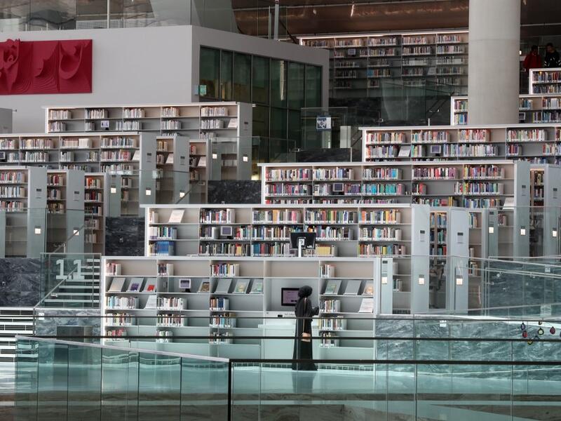 A woman chooses books at the Qatar National Library in the capital Doha.  KARIM JAAFAR / AFP