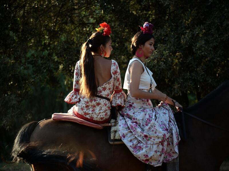 El Rocio pilgrimage, the largest in Spain, gathers hundreds of thousands of devotees in traditional outfits converging in a burst of colour as they make their way on horseback and on board decorated carriages across the Andalusian countryside. CRISTINA QUICLER / AFP
