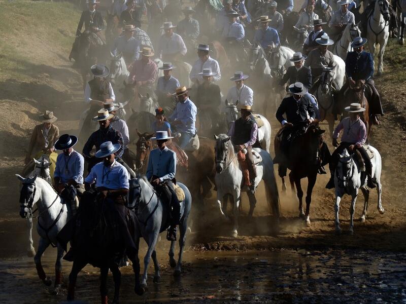 Pilgrims cross the Quema river in Villamanrique, during a pilgrimage on their way to the village of El Rocio.  CRISTINA QUICLER / AFP