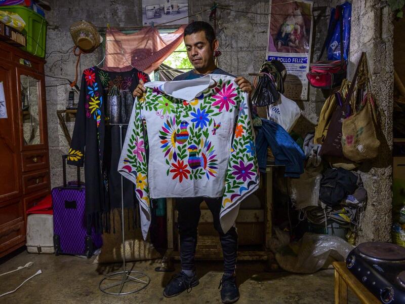 Mexican artisan of the Otomi ethnic group Oliver Teodoro Lopez, shows one of his designs at his workshop in San Nicolas Village, in Tenango de Doria, Hidalgo state, Mexico.  Pedro PARDO / AFP