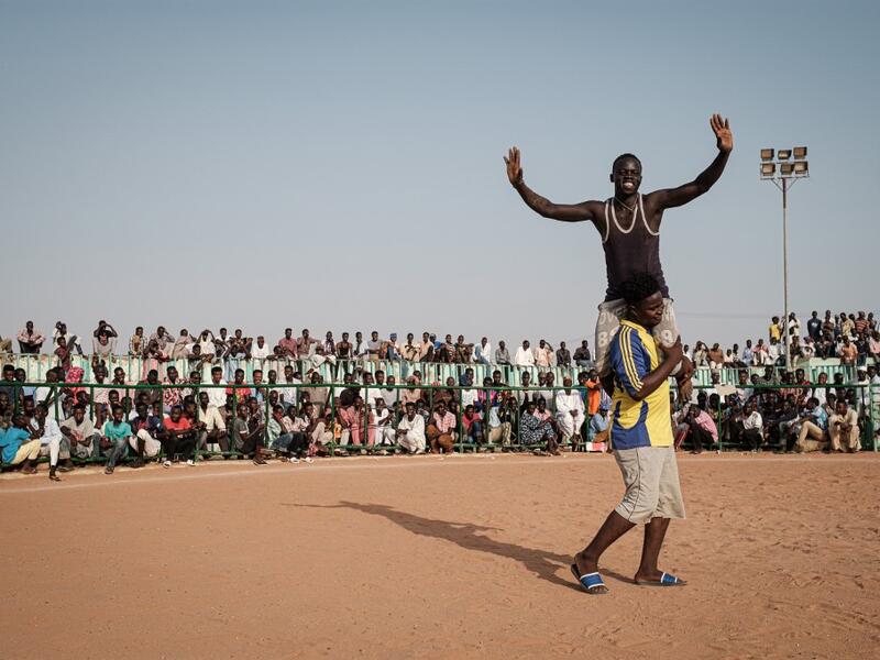 A Sudanese wrestler reacts after winning during a traditional Nuba wrestling match at the Haj Youssef stadium in the district of Khartoum.  Yasuyoshi CHIBA / AFP