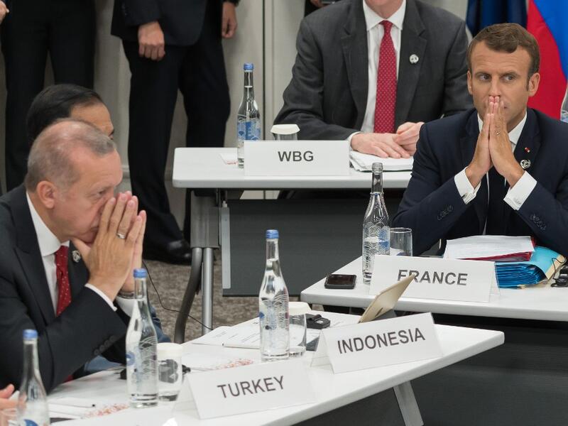 Turkey's President Recep Tayyip Erdogan (L) and France's President Emmanuel Macron gesture as they attend a meeting on the digital economy at the G20 Summit in Osaka on June 28, 2019.  Jacques Witt / POOL / AFP
